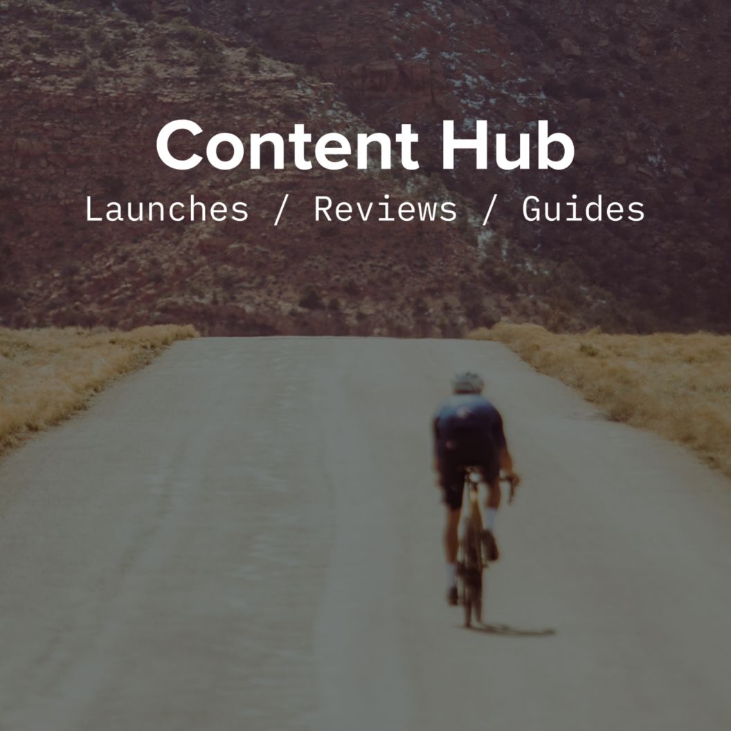 A rider sprints alone on an open road. Content Hub: launches, reviews, guides text is over the image. 
