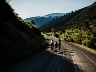 Riders pedal a smooth gravel road in the foothills.