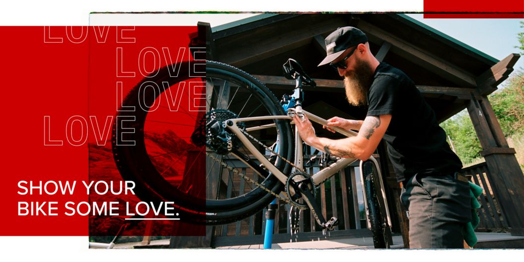 A gearhead washes his mountain bike. A text overlay reads, “Show your bike some love.”