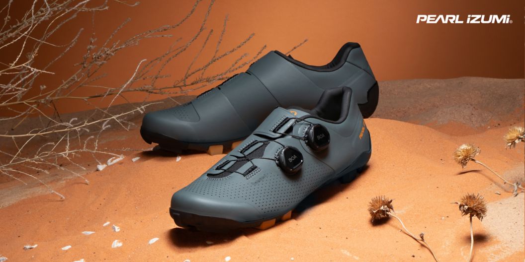 Pearl Izumi Expedition Pro shoes are shown in a staged desert landscape.