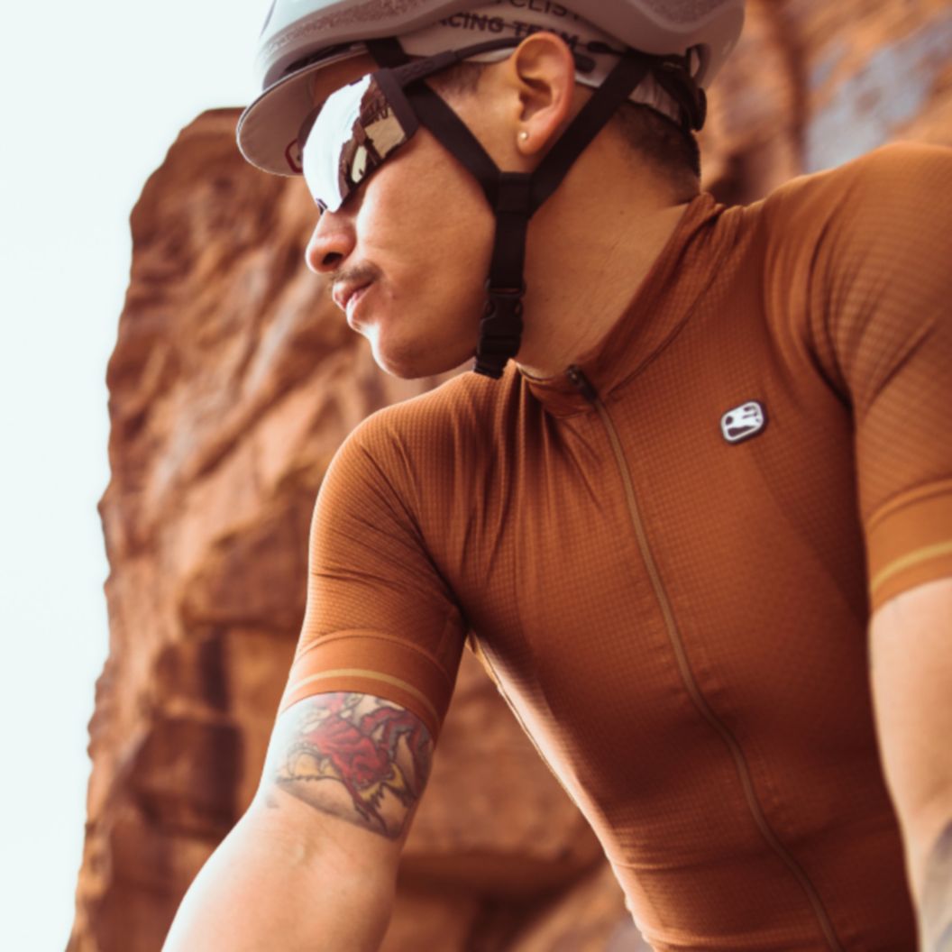 2023 Road Apparel Lookbook text over a photo of a rider in a summer kit under a towering wall of red rock.