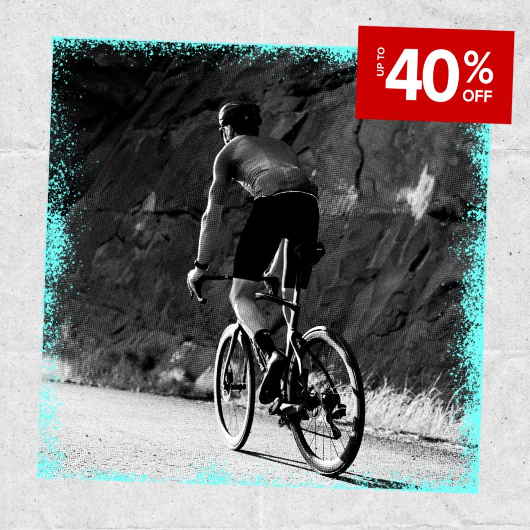 Up to 40% off discount sticker over a black and white image of a cyclist in summer kit riding.
