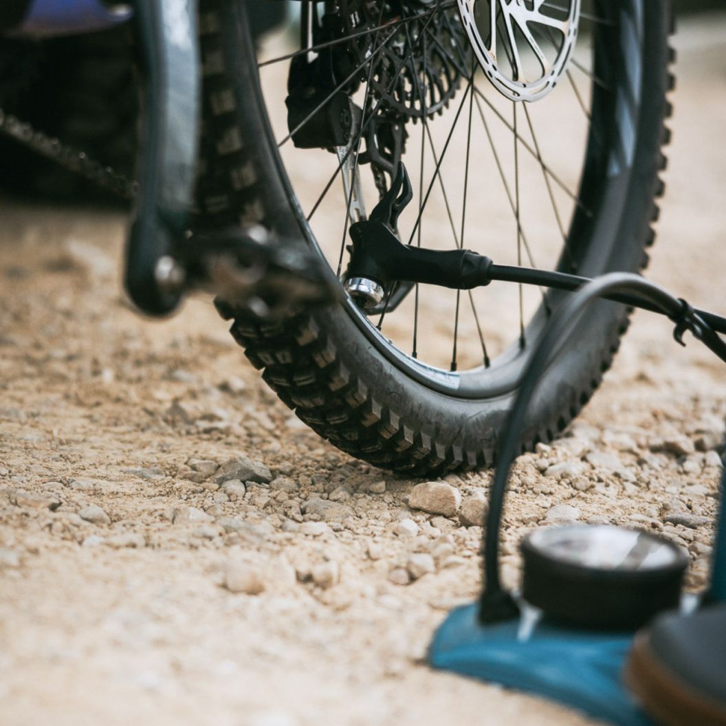 A rider pumps up a mountain bike tire at the trail head parking lot.