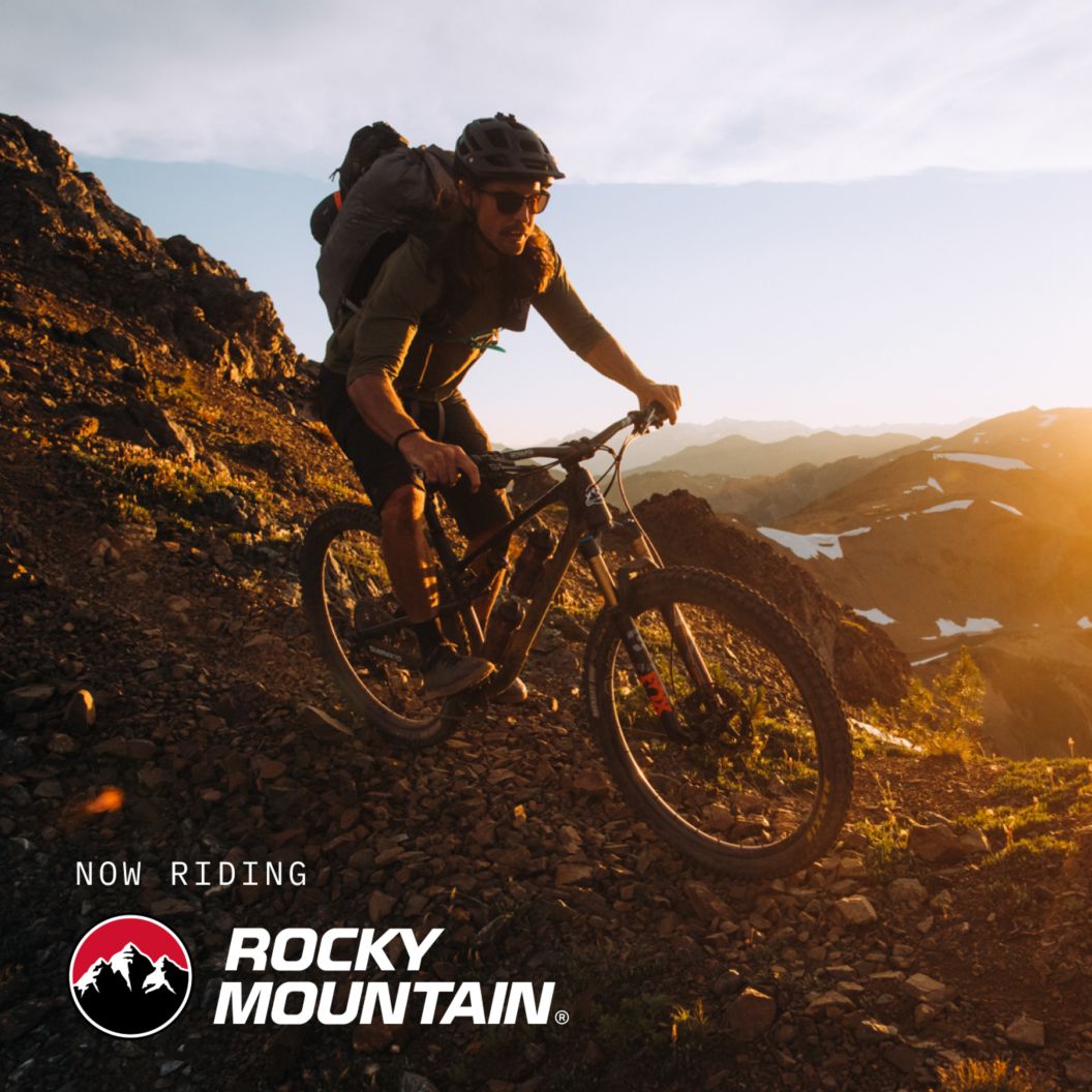 Now riding Rocky Mountain bikes text on an image of a rider descending a high-altitude rocky trail.