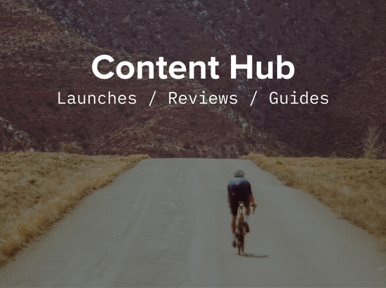 A rider sprints alone on an open road. Content Hub: launches, reviews, guides text is over the image. 