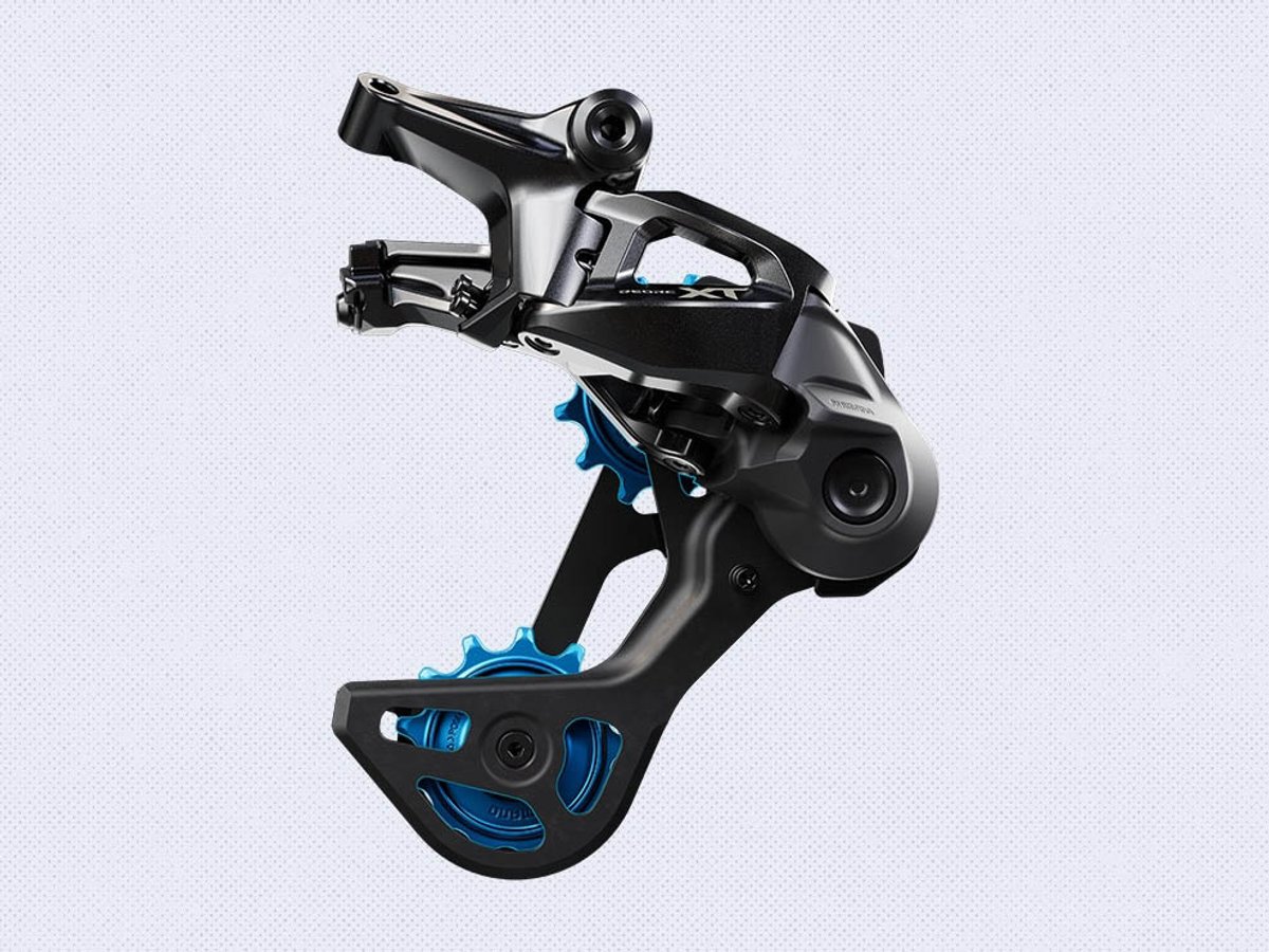 Shimano Deore XT rear derailleur isolated on a light gray background, showing black body with blue anodized pulley wheels.