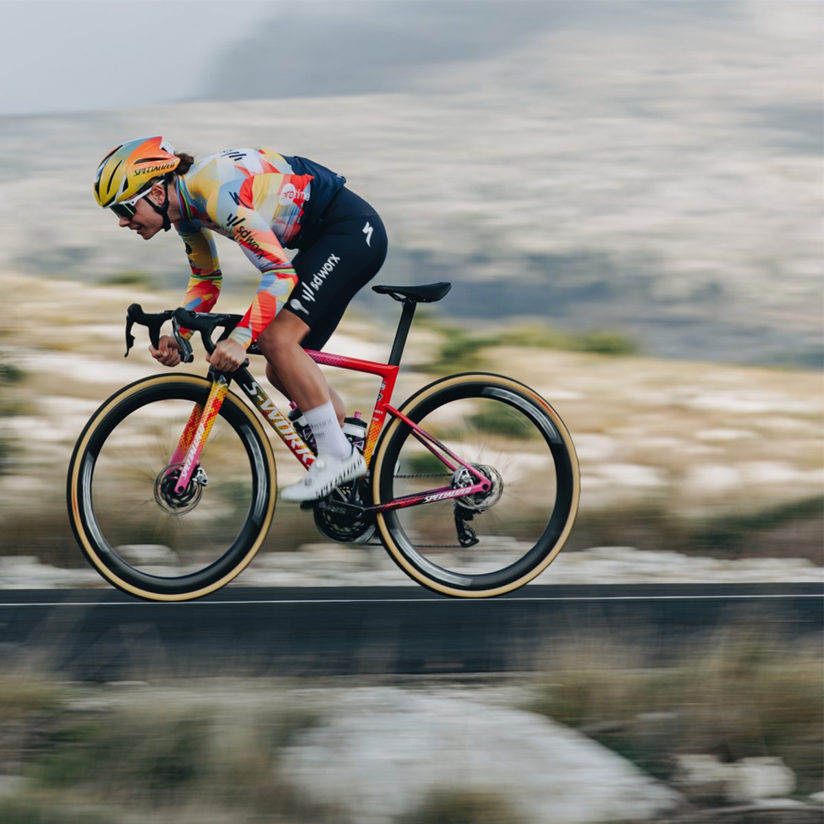 A person rides a bike down a road, wearing the Evade 4.