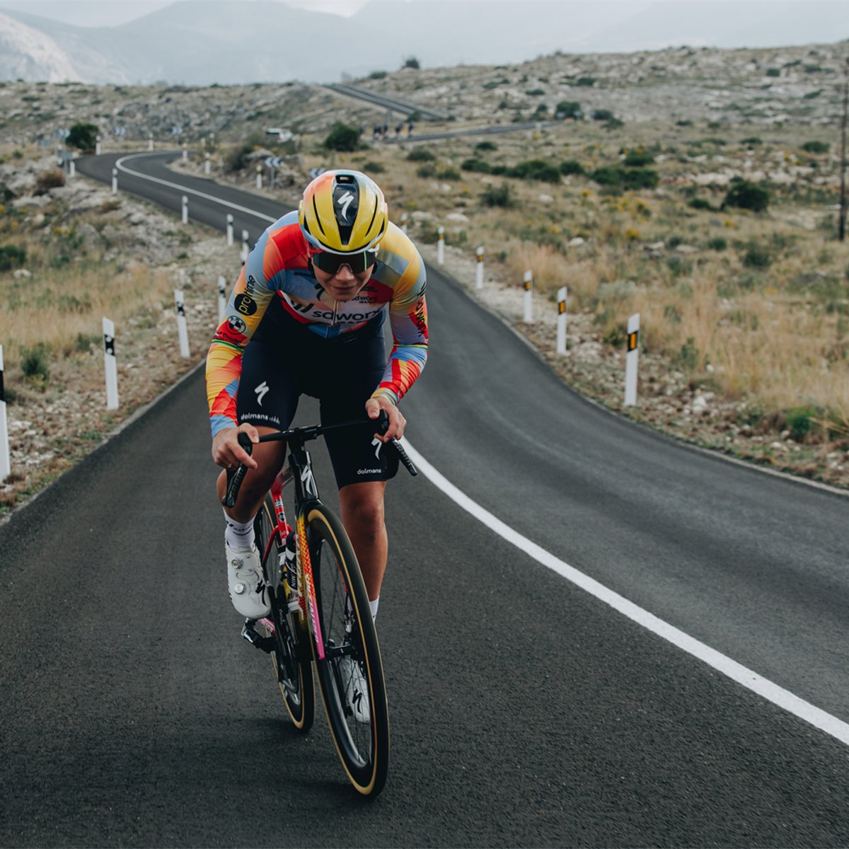A person rides a bike down a road, wearing the Evade 4.