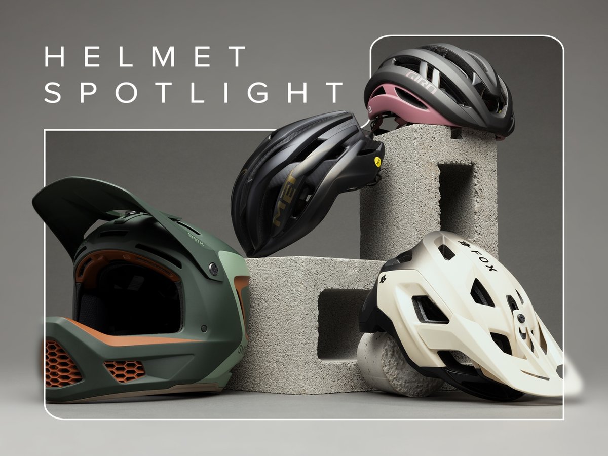 An assortment of helmets sits among cinder blocks. Text overlay reads: Helmet Spotlight