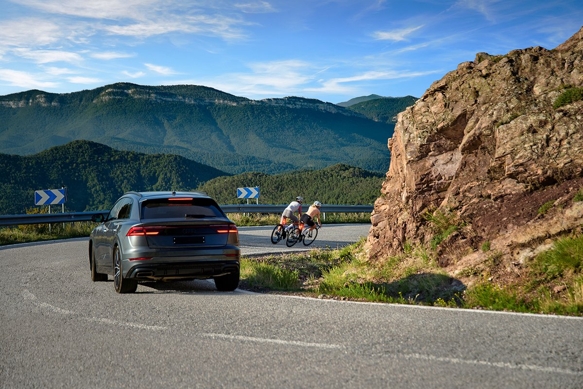 Road cyclists climbing mountain pass with rear safety lights on