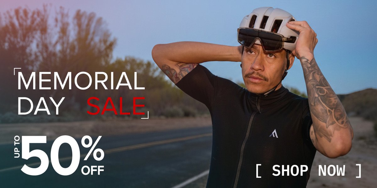 Cyclist adjusting helmet on a desert road at dusk. Memorial Day Sale — up to 50% off