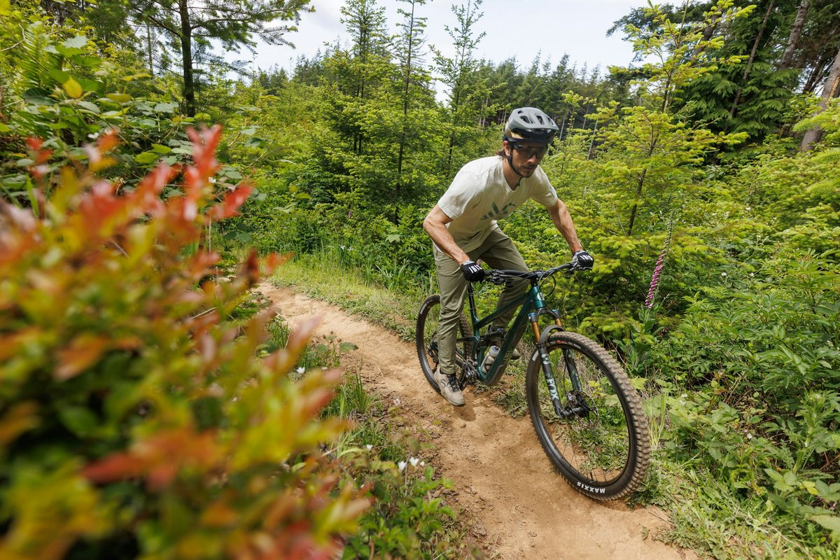 Rider coming around a corner on sirt single track trail.