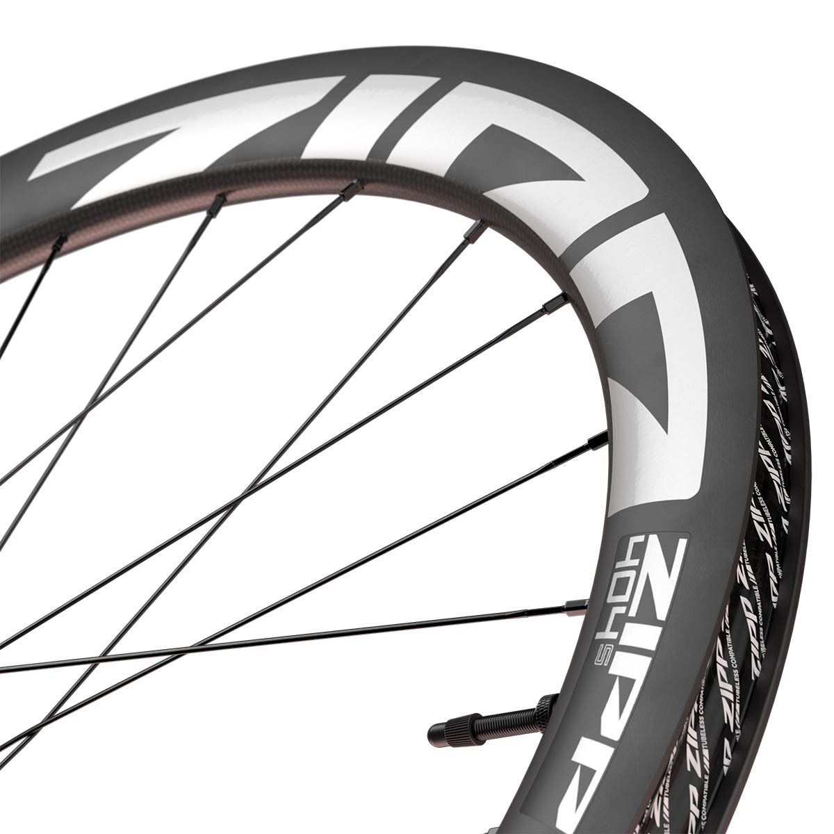 Close-up of the Zipp 404 S carbon rim showing the deep aero profile, white logo graphics, and valve stem.