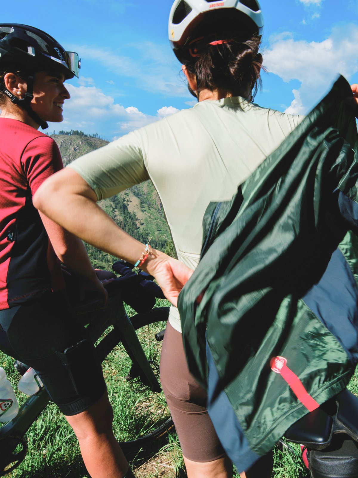 Two gravel riders stand and layer for the ride.