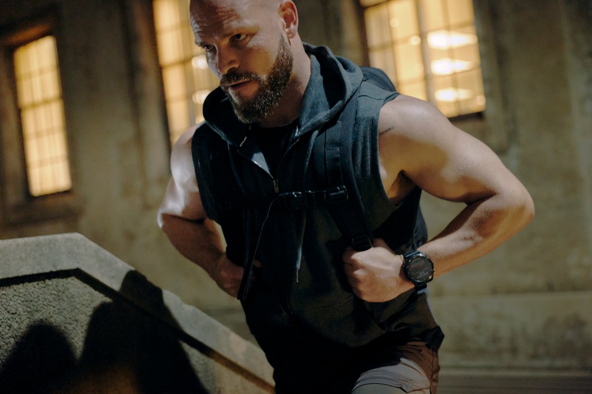 Person wearing backpack wearing Garmin Fenix 9 watch.