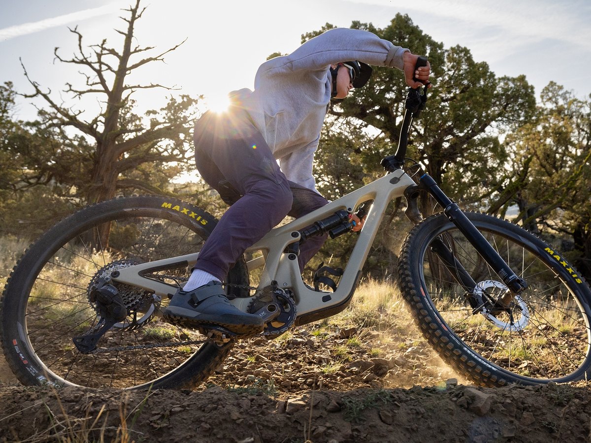 A mountain biker leans into a turn. Their bike’s frame is conspicuously free of cord clutter.