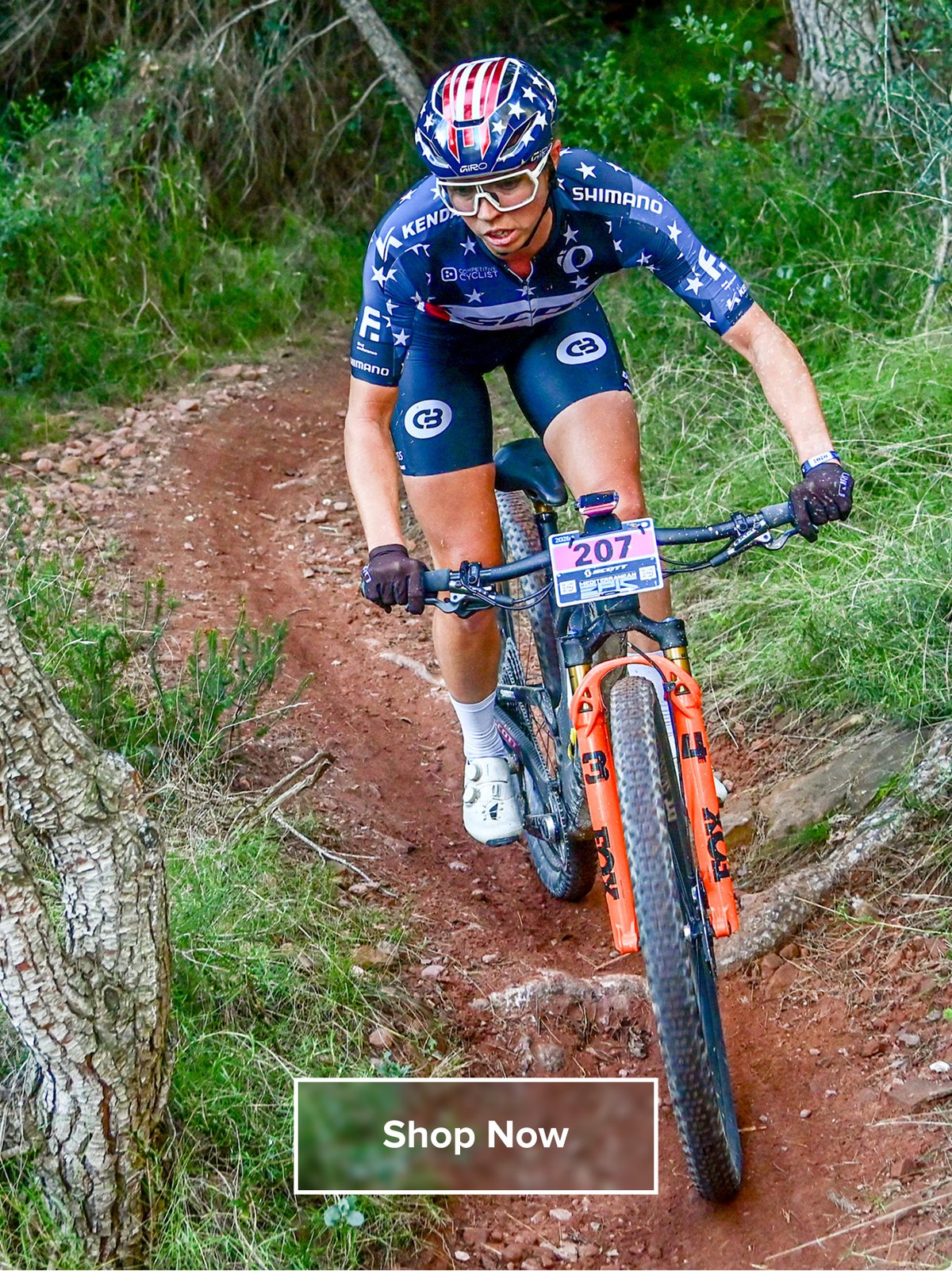 Hannah descending during a mountain bike race in her stars and stripes kit.