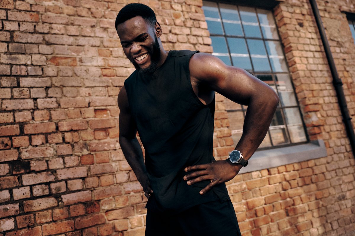 Person standing against brick wall wearing Garmin Fenix 9 watch.
