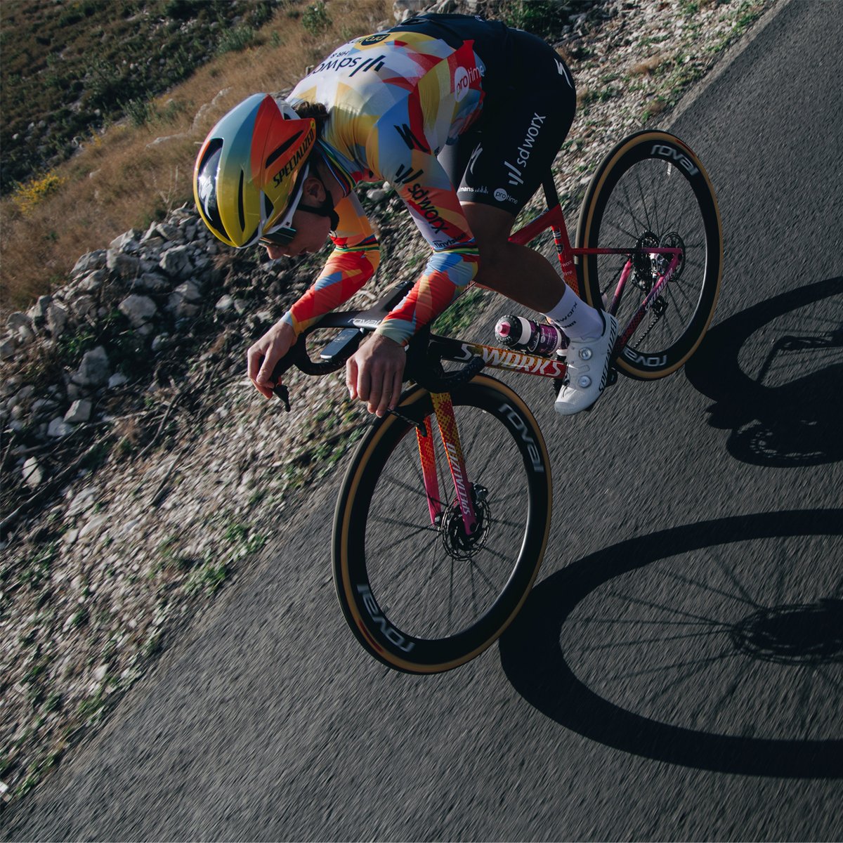 A person rides a bike down a road, wearing the Evade 4.