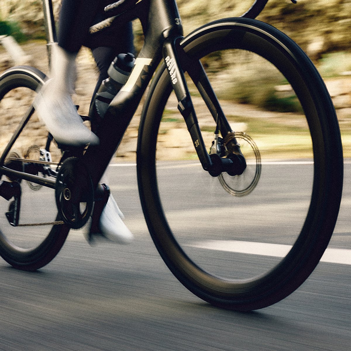 A slightly blurry image of a bike with someone pedaling fast. The Continental logo is across the center.