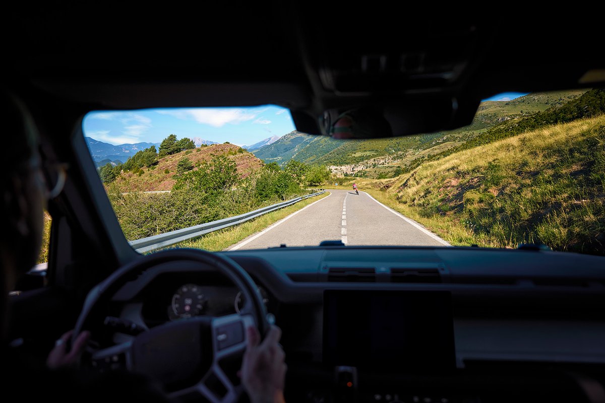 Motorist approaching cyclist on scenic two-lane road