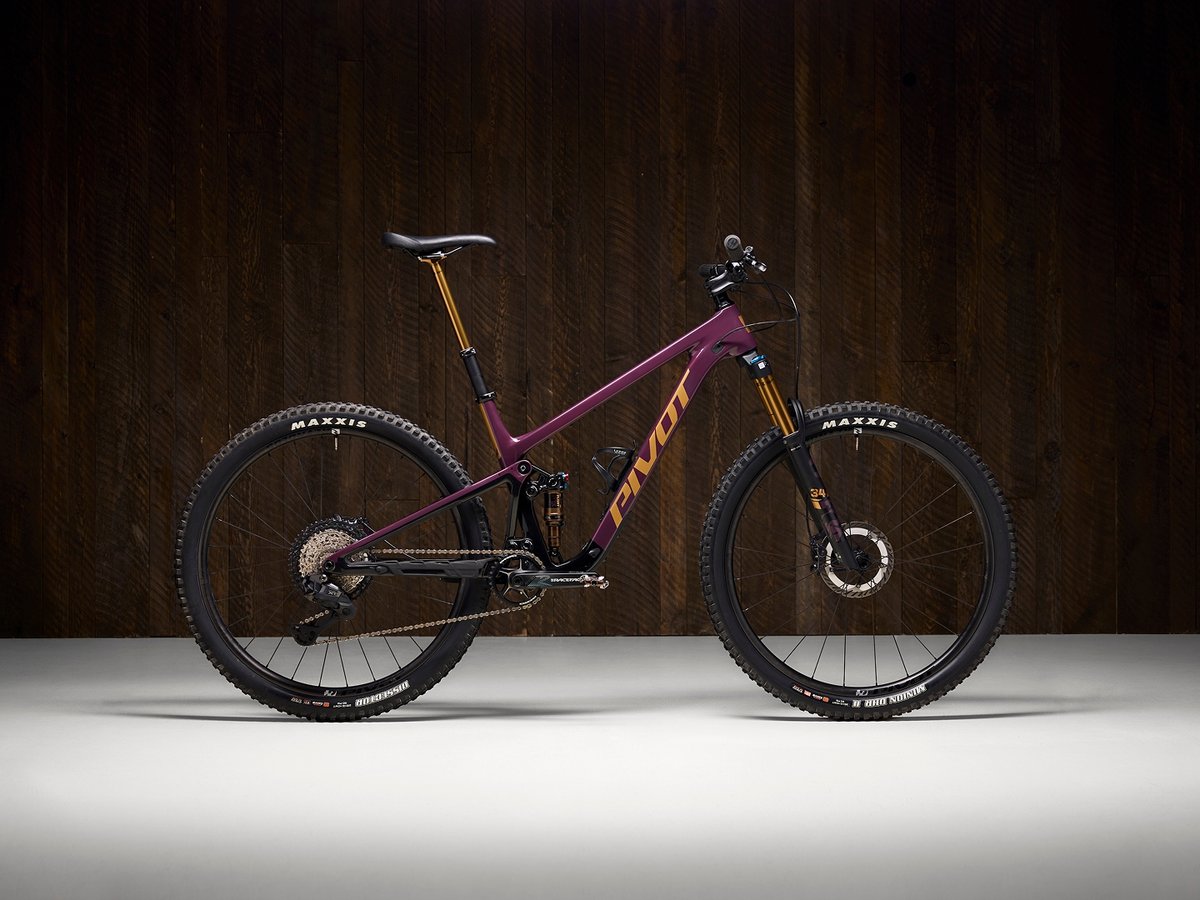 Pivot Trailcat SL Pro mountain bike shown against a dark wood studio background.