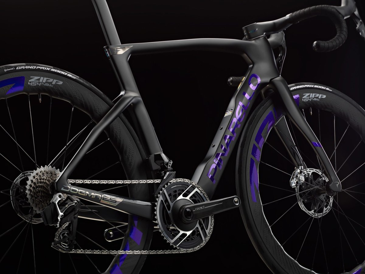 Pinarello Dogma F Edizione Speciale frame in matte black carbon with bold purple graphics, SRAM Red groupset, and Zipp 454 NSW wheels with Continental Grand Prix 5000 tires, shot against a dark studio background.
