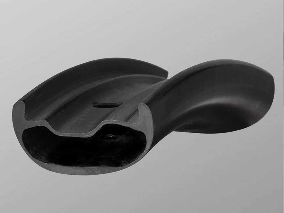 Angled cross-section of a black carbon mountain bike rim showing the internal chamber shape, on a gray background.