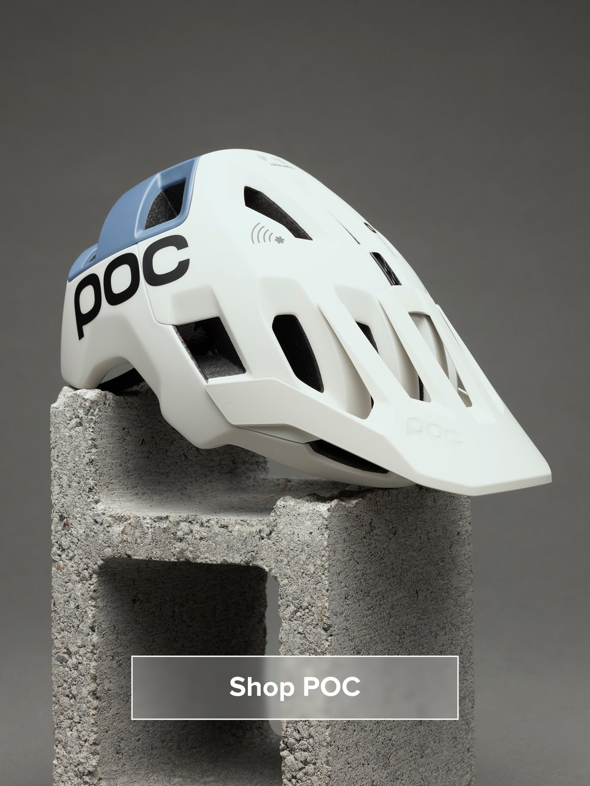 A helmet sits on a cinder block. Button reads: Shop POC