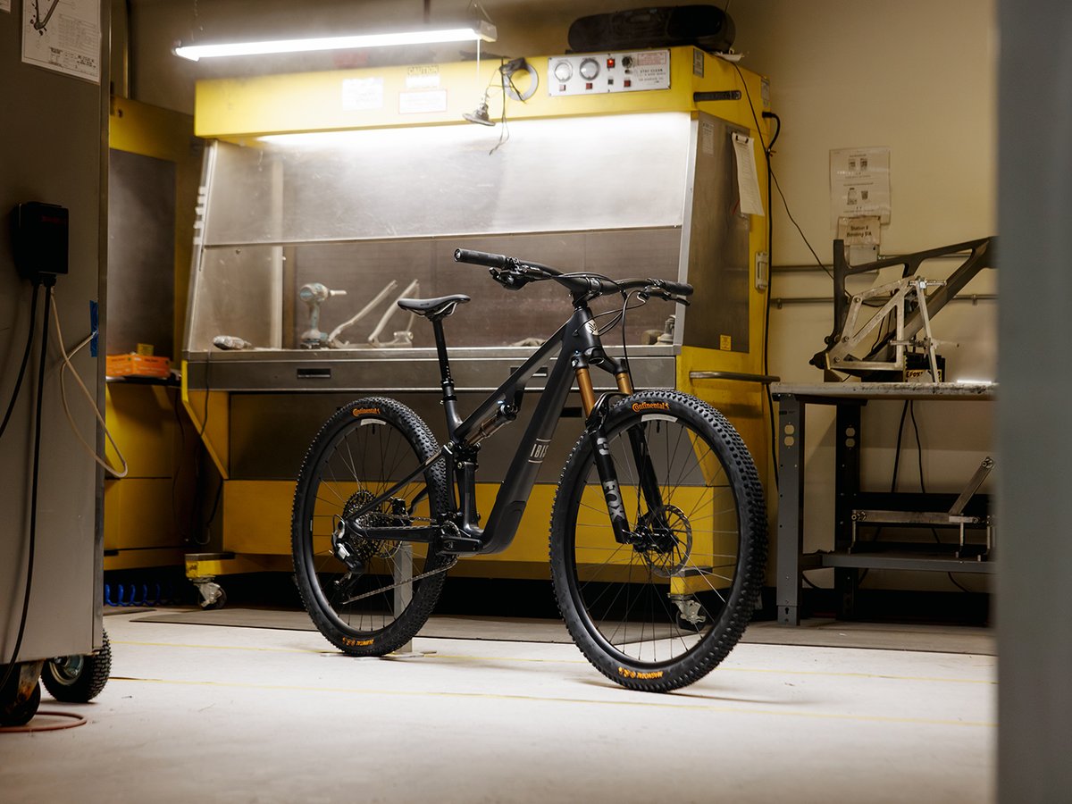 Black Ibis mountain bike standing in front of factory equipment.