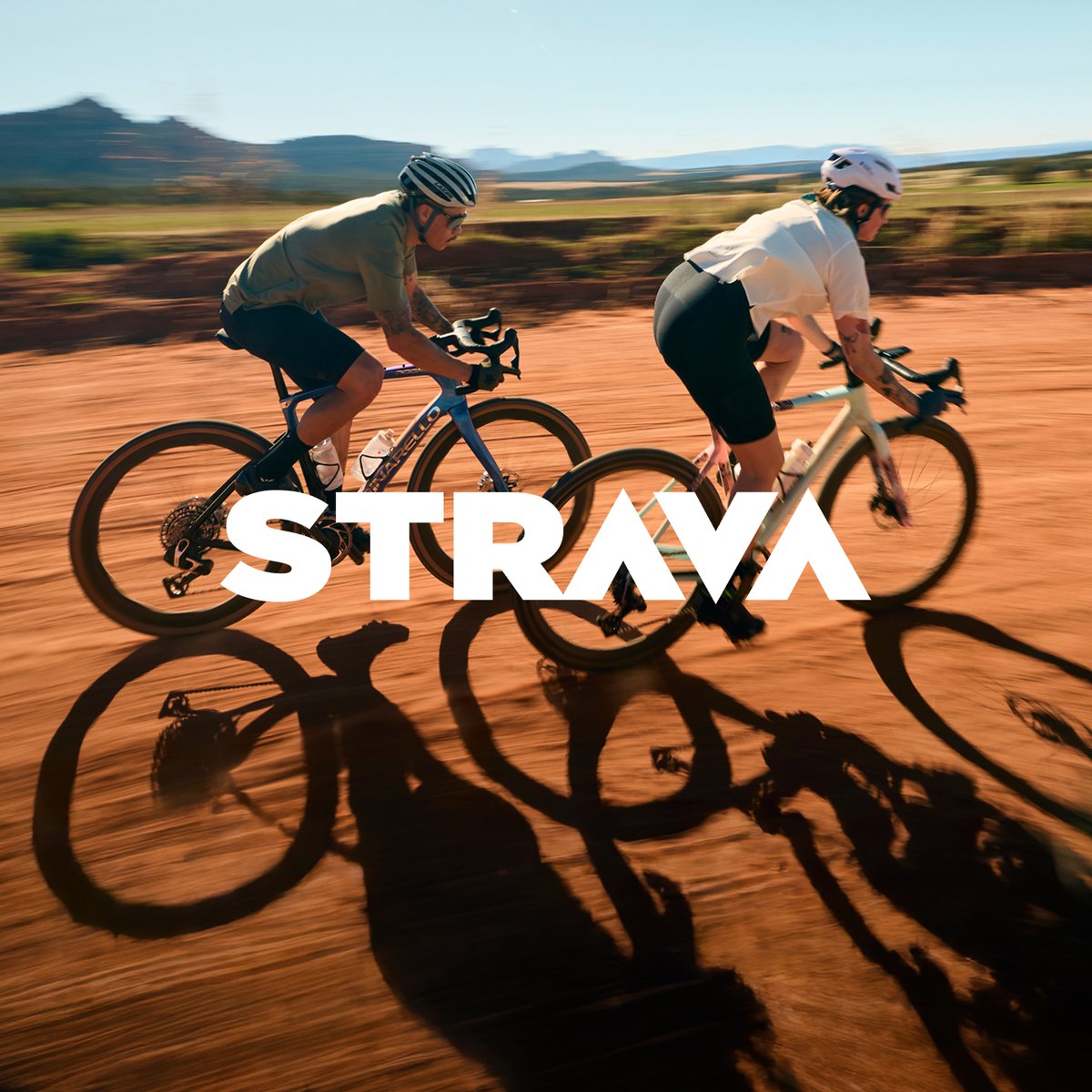 Two cyclists ride gravel bikes on a dirt road, text over the image reads strava