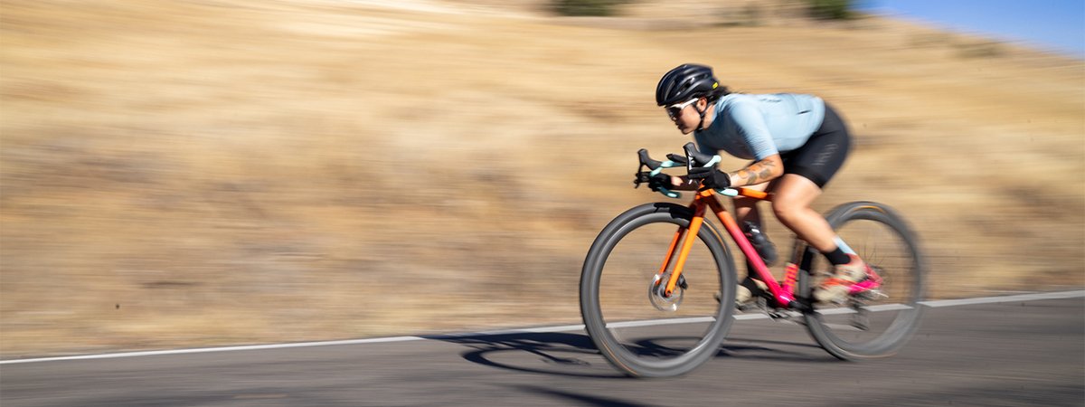Cyclict riding fast on a paved road.