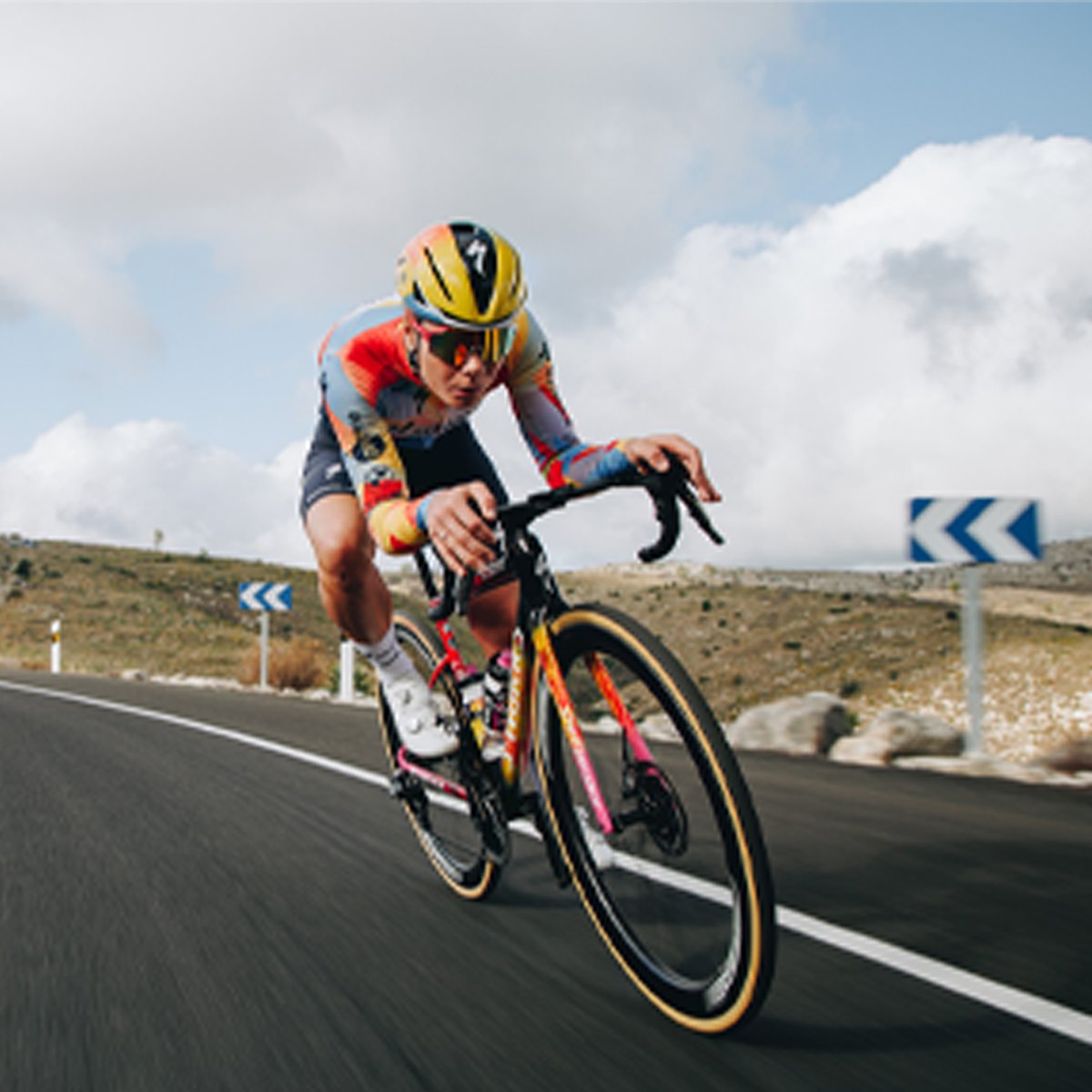 A person rides a bike down a road, wearing the Evade 4.