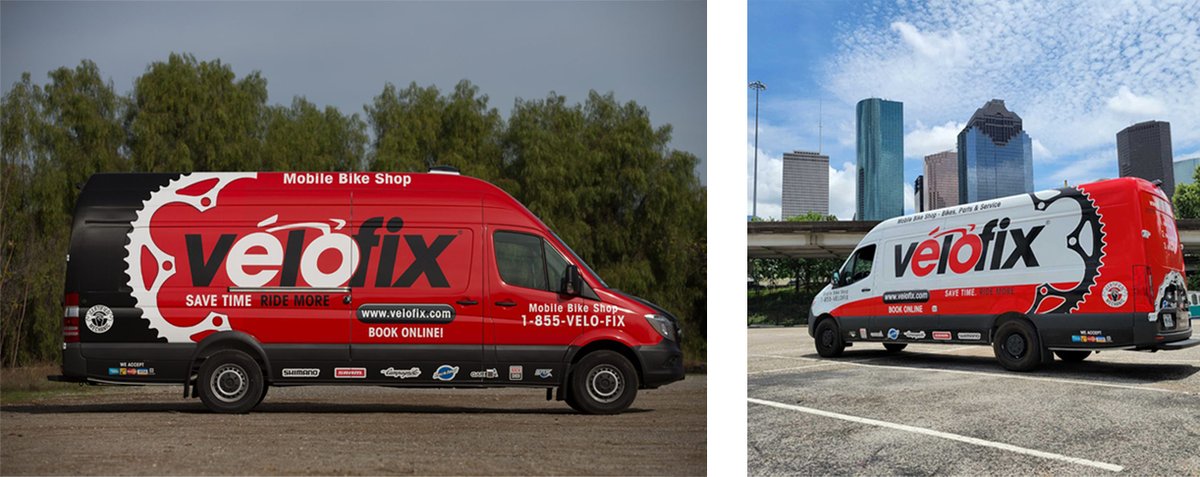 A side view of a red velofix van parked on asphalt. Next to it, another velofix van is parked at an angle.