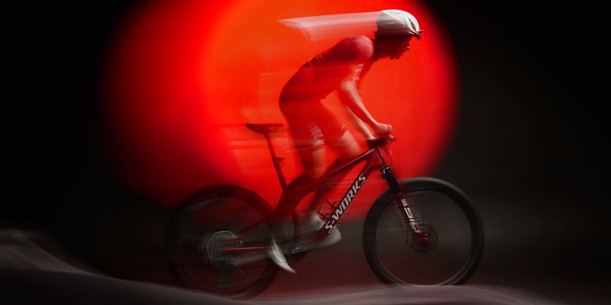 Rider on Epic 9 ike with red spotlight and blurred motion lines.