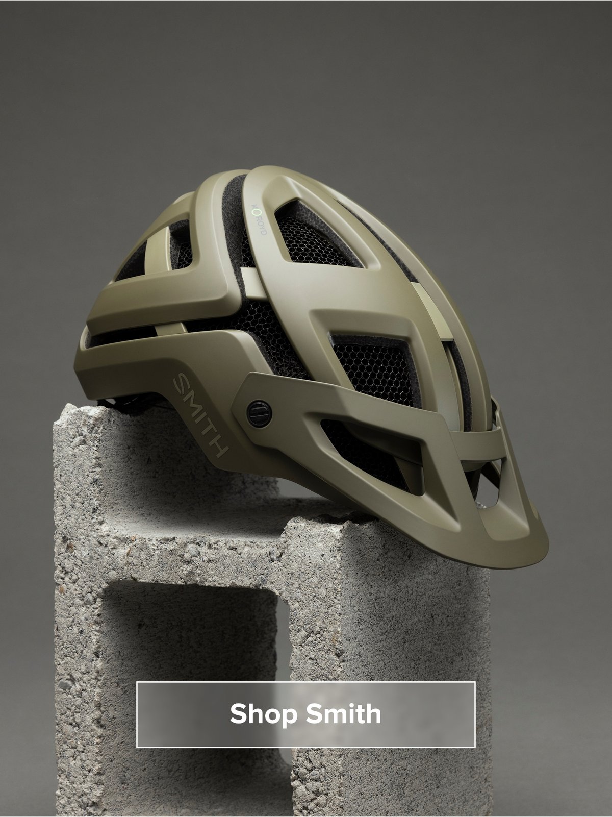 A helmet sits on a cinder block. Button reads: Shop Smith
