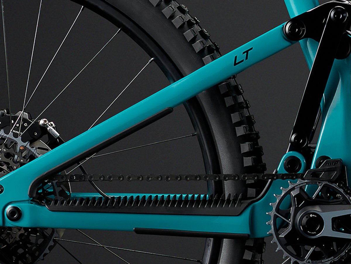 Chainstay detail showing a molded rubber chain slap guard along the driveside stay, protecting the frame from chain contact.