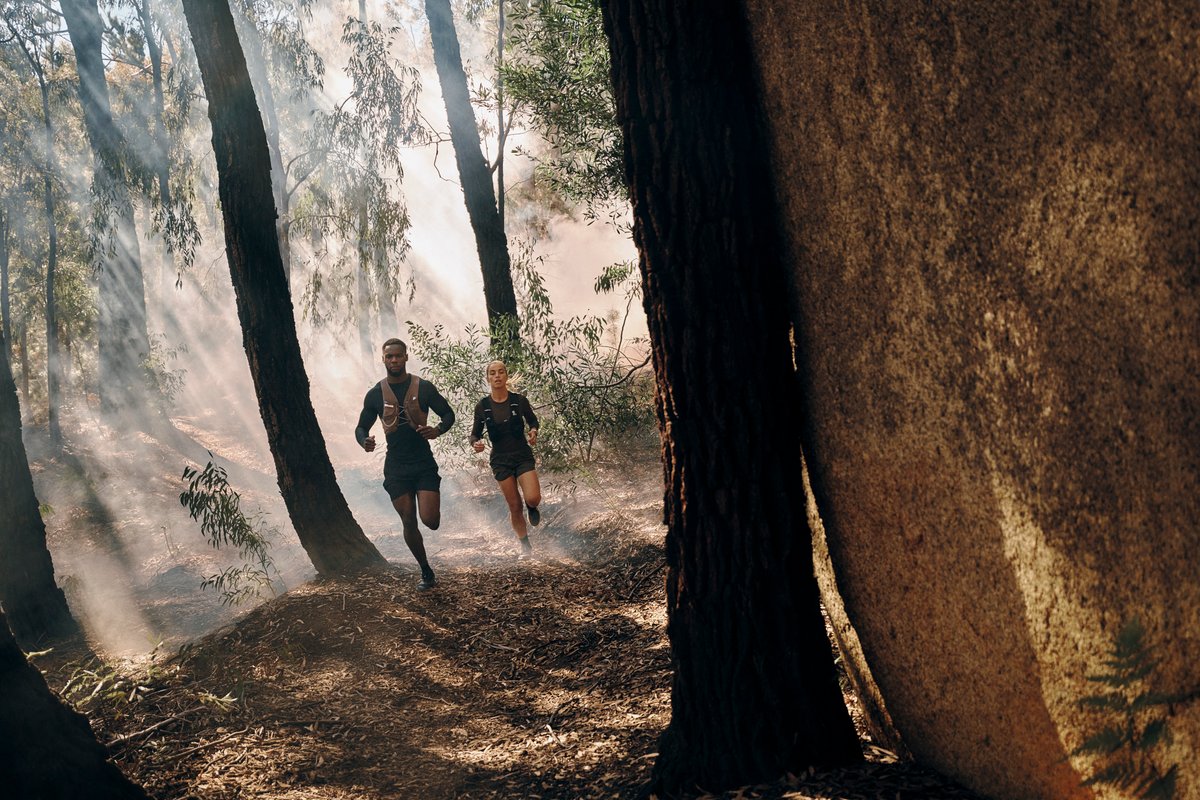 Two p[eople running through forest wearing Garmin Fenix 9 watch.