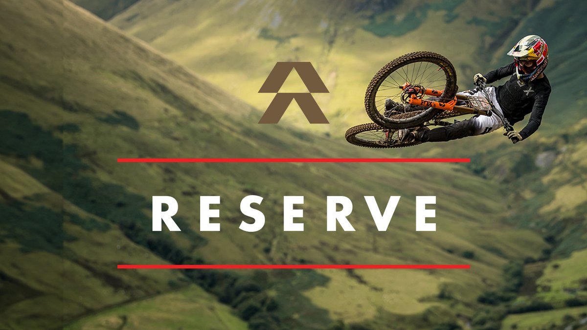Claude responded: Reserve brand card with logo and wordmark over a background photo of a rider whipping an orange mountain bike above a green highland hillside.Reserve brand card with logo and wordmark over a background photo of a rider whipping an orange mountain bike above a green highland hillside.