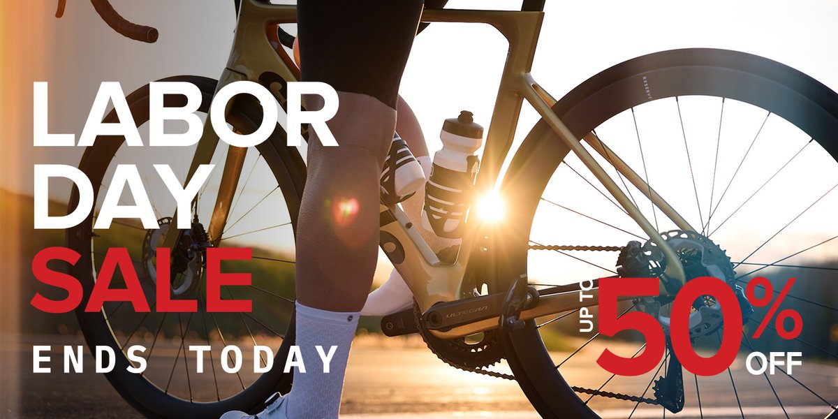 A close-up of a cyclist next to a road bike with sunlight shining through the frame, overlaid with the text: "Labor Day sale ends today. Up to 50% off."