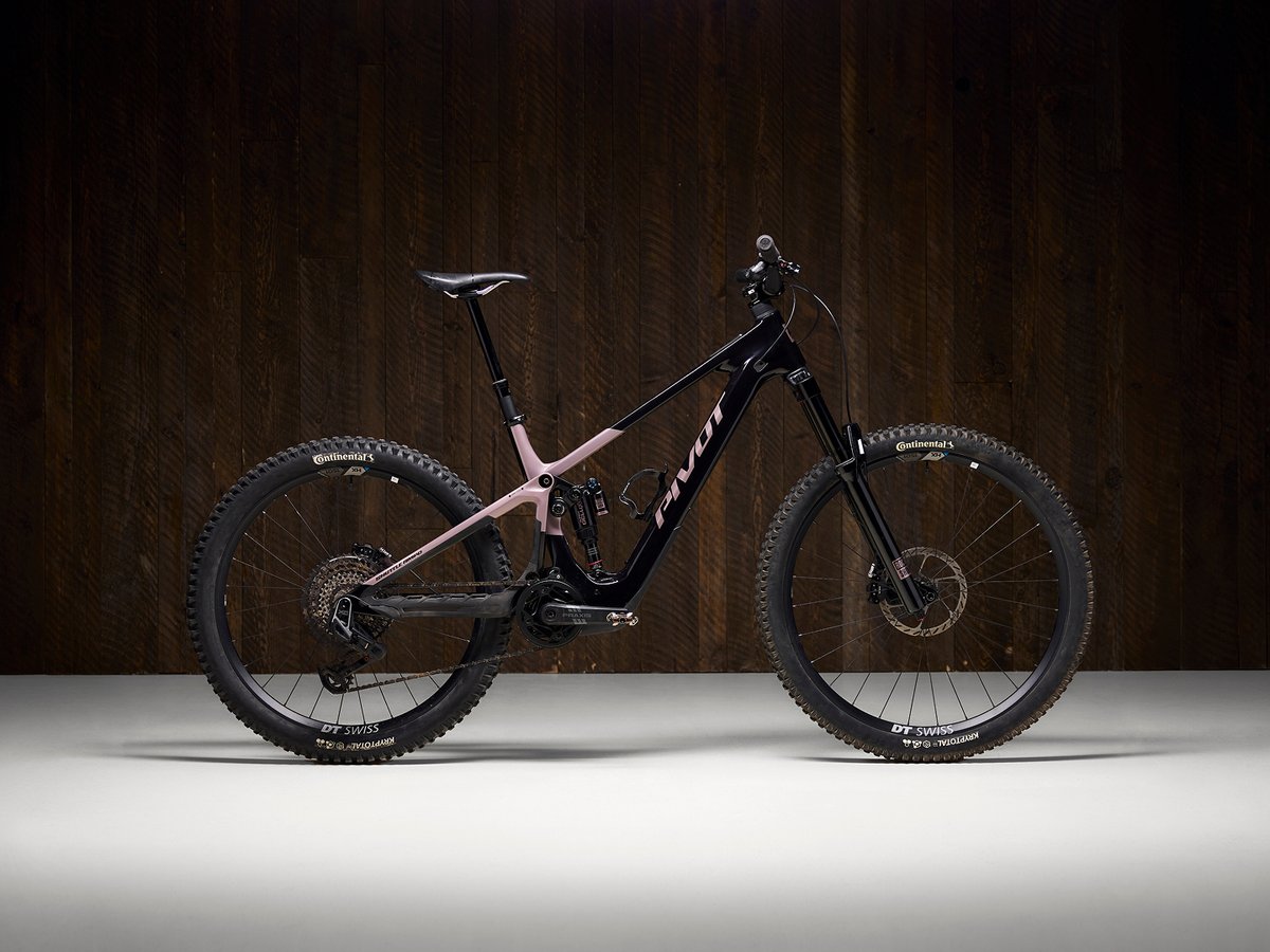 Pivot Shuttle AMP'd Pro electric mountain bike shown against a dark wood studio background.