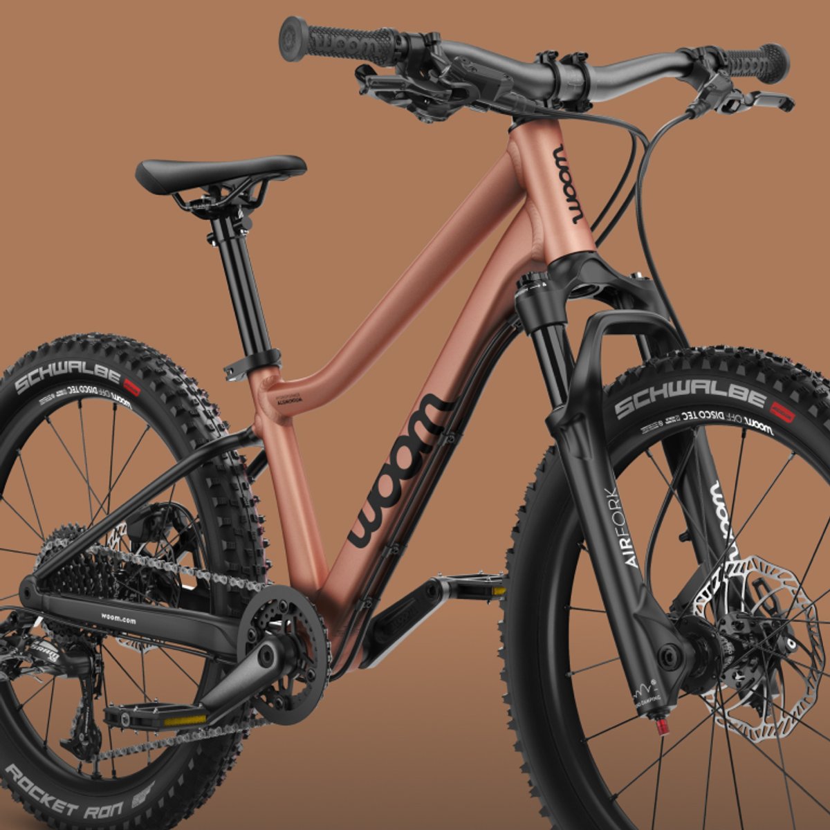 Three-quarter front view of the Woom Off Air bike in copper.