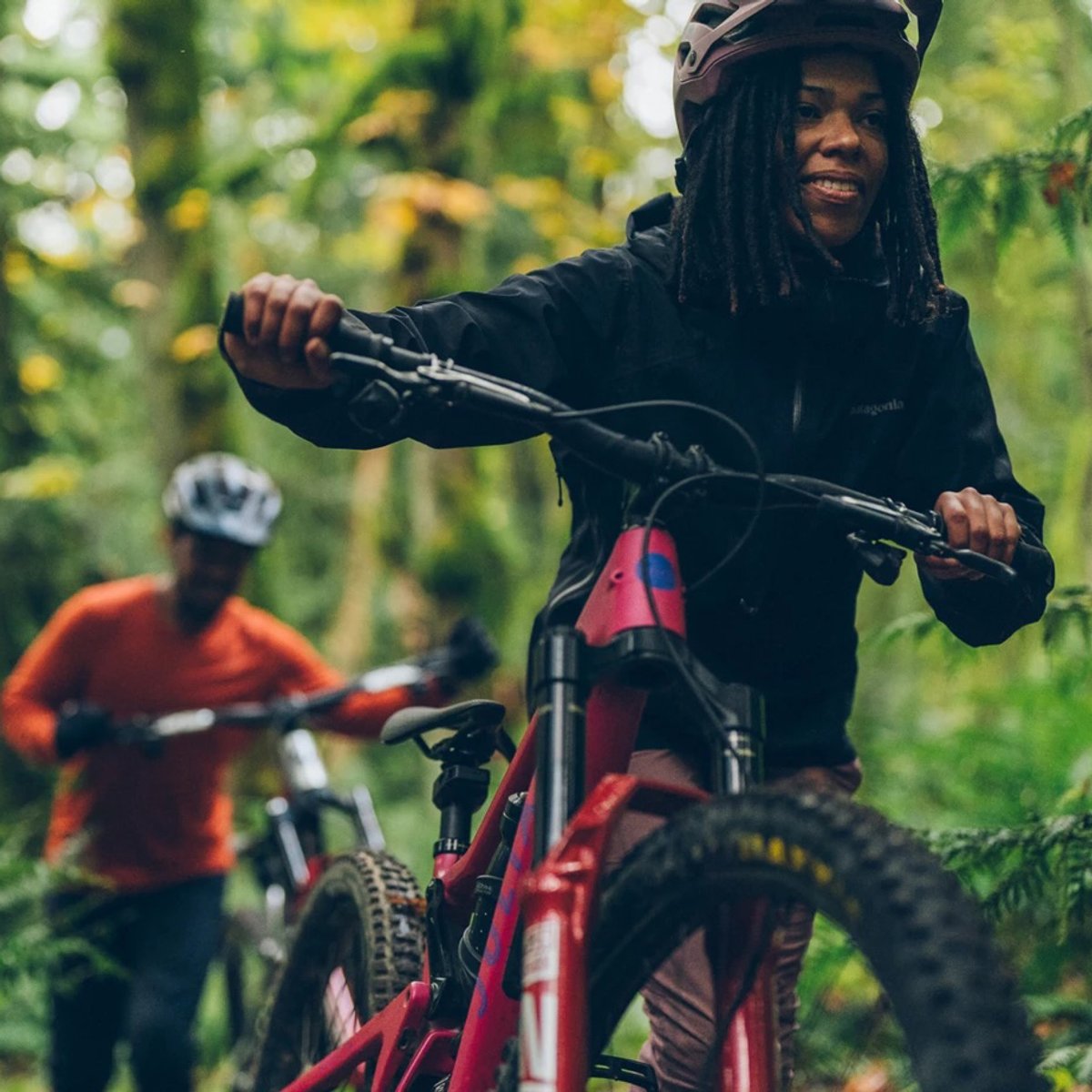 Mountain biker pushing her bike.