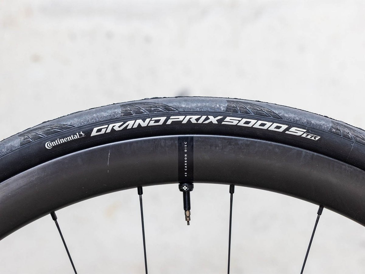 Continental Grand Prix 5000 S TR tire mounted on a black carbon disc wheel.