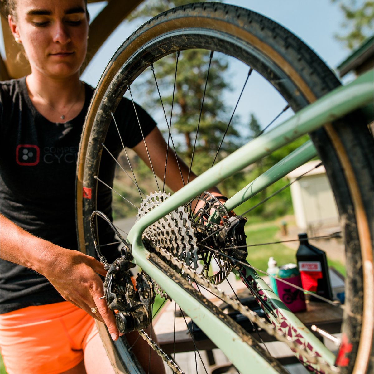 A Gearhead with a Competitive Cyclist shirt performing maintenance to a Bike 
