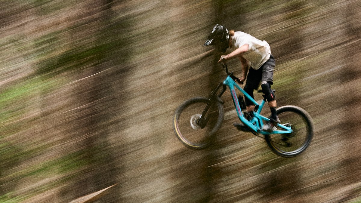 Rider getting air in teh trees riding the Nomad bike.