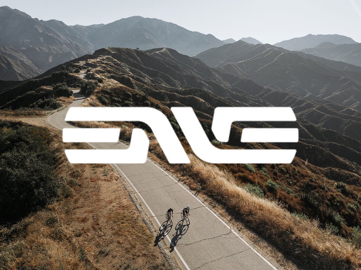 Enve logo overlayed on mountain foothill scene with road cyclists below.