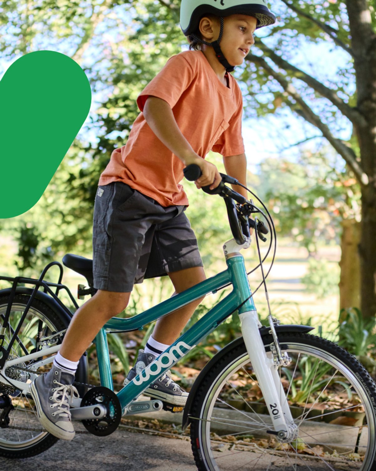 Kid pedaling a Woom bike at a park.