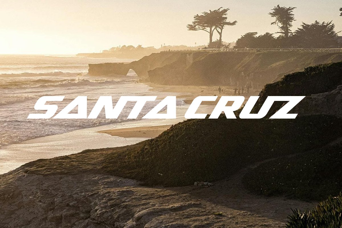 Sanat Cruz logo overlayed on sunset beach silhouette.