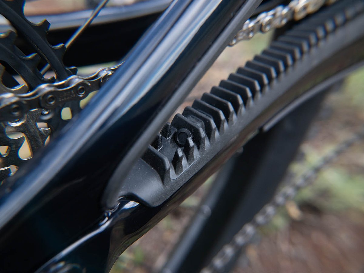 Detail of the ribbed rubber chainstay guard on the Yeti MT carbon frame, with chain and cassette in the background.
